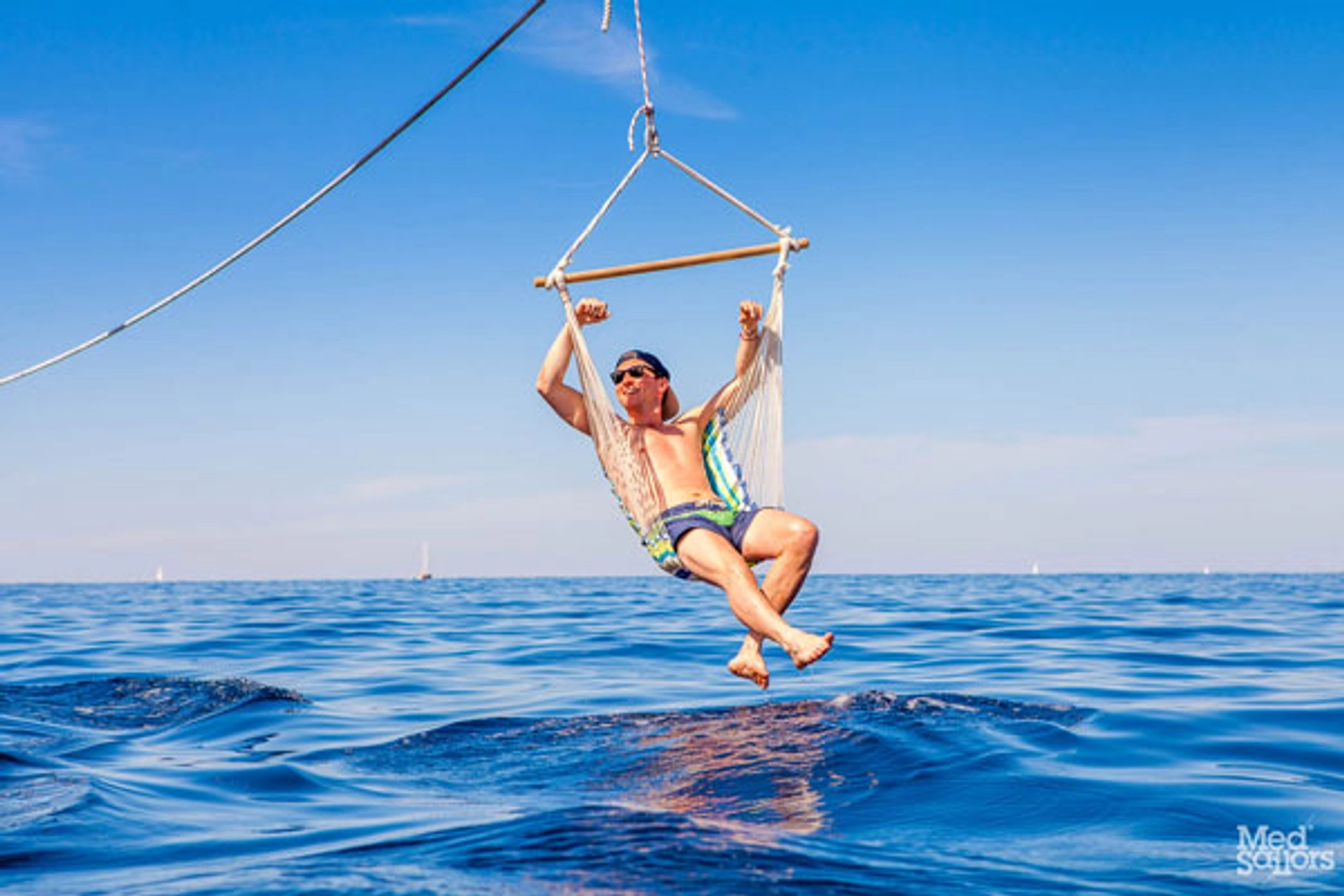 Man on a hammock hanging over the ocean