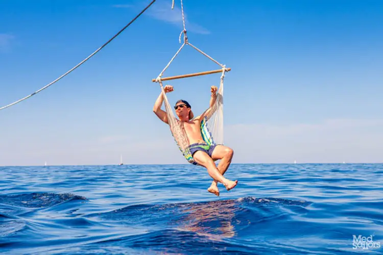 Man on a hammock hanging over the ocean