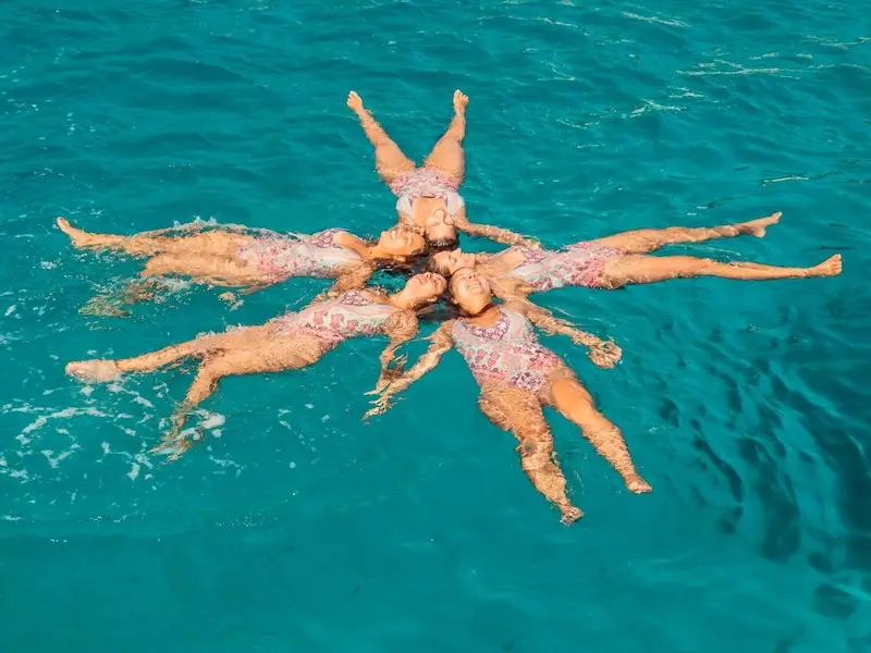 Group of female solo travellers on a Greece budget travel adventure floating together in a beautiful bay while on a trip with MedSailors.