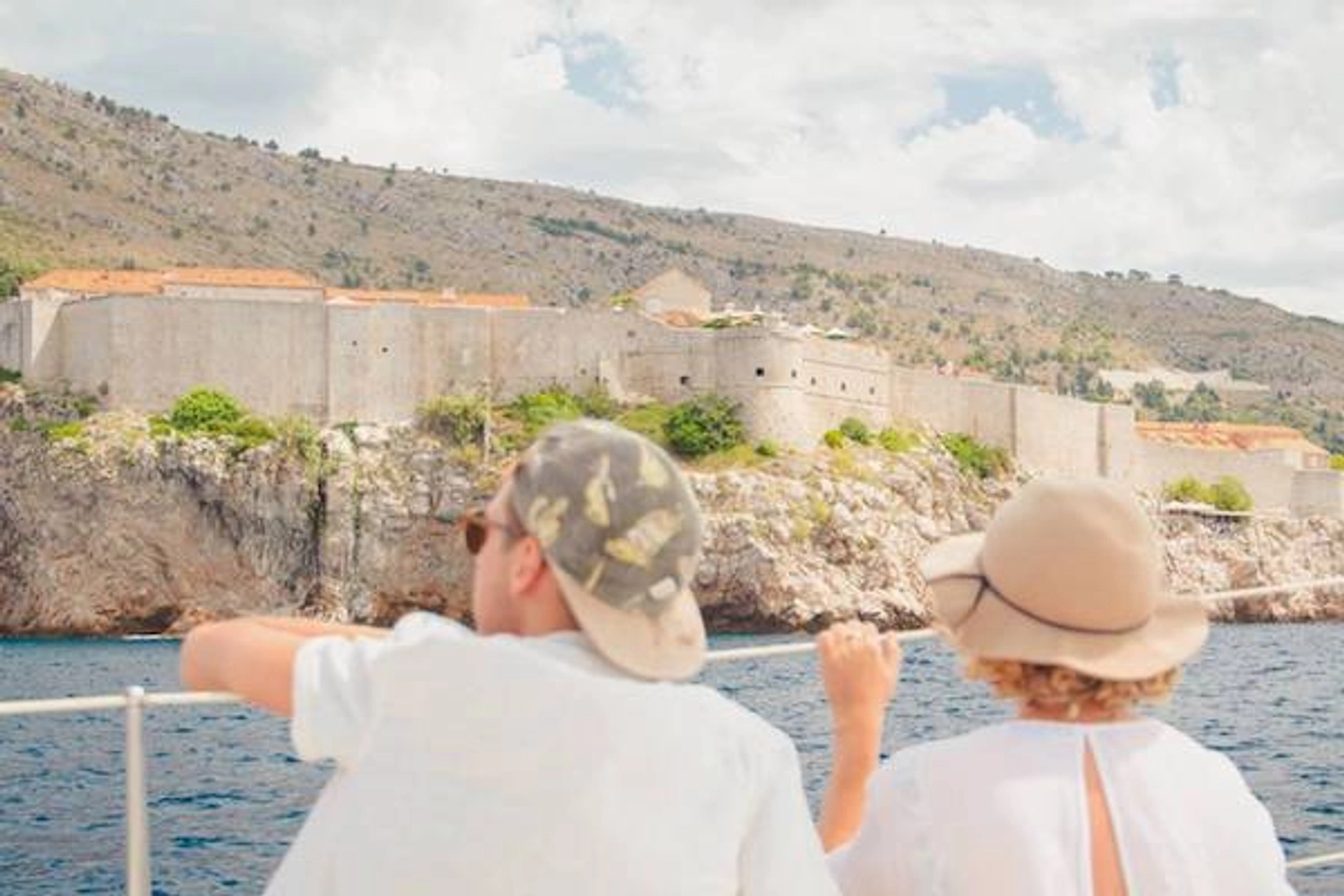 Couple look from a yacht towards the town walls of Dubrovnik