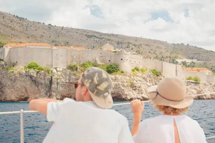 Couple look from a yacht towards the town walls of Dubrovnik