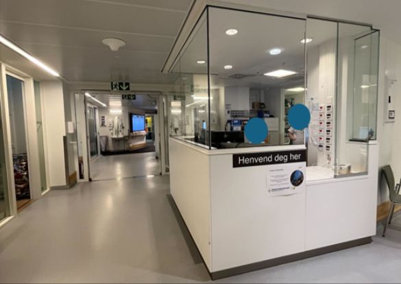 Delvis innglasset resepsjon med et skilt som har teksten "Henvend deg her".