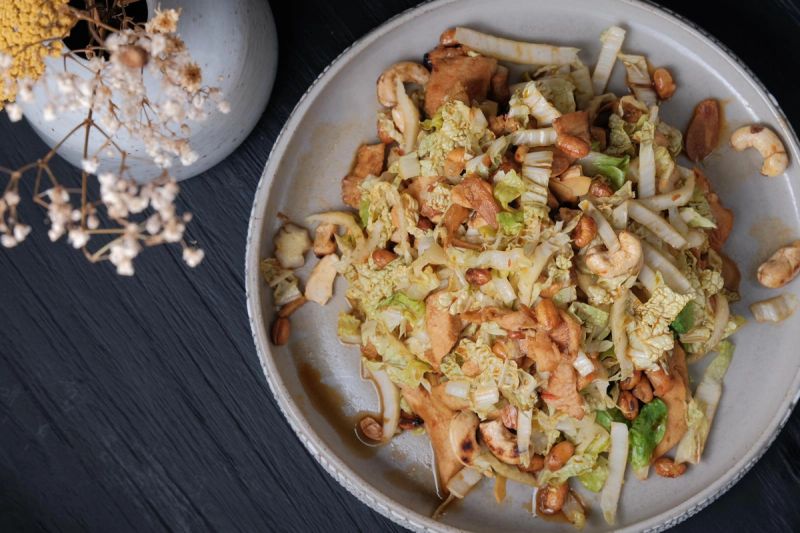 Crunchy ginger salad with crispy soybeans and nuts in a ceramic bowl.