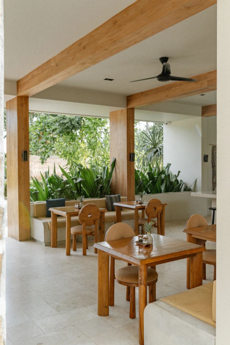 Teak dining tables and cushioned seating in the open-sided Boni Beach restaurant.
