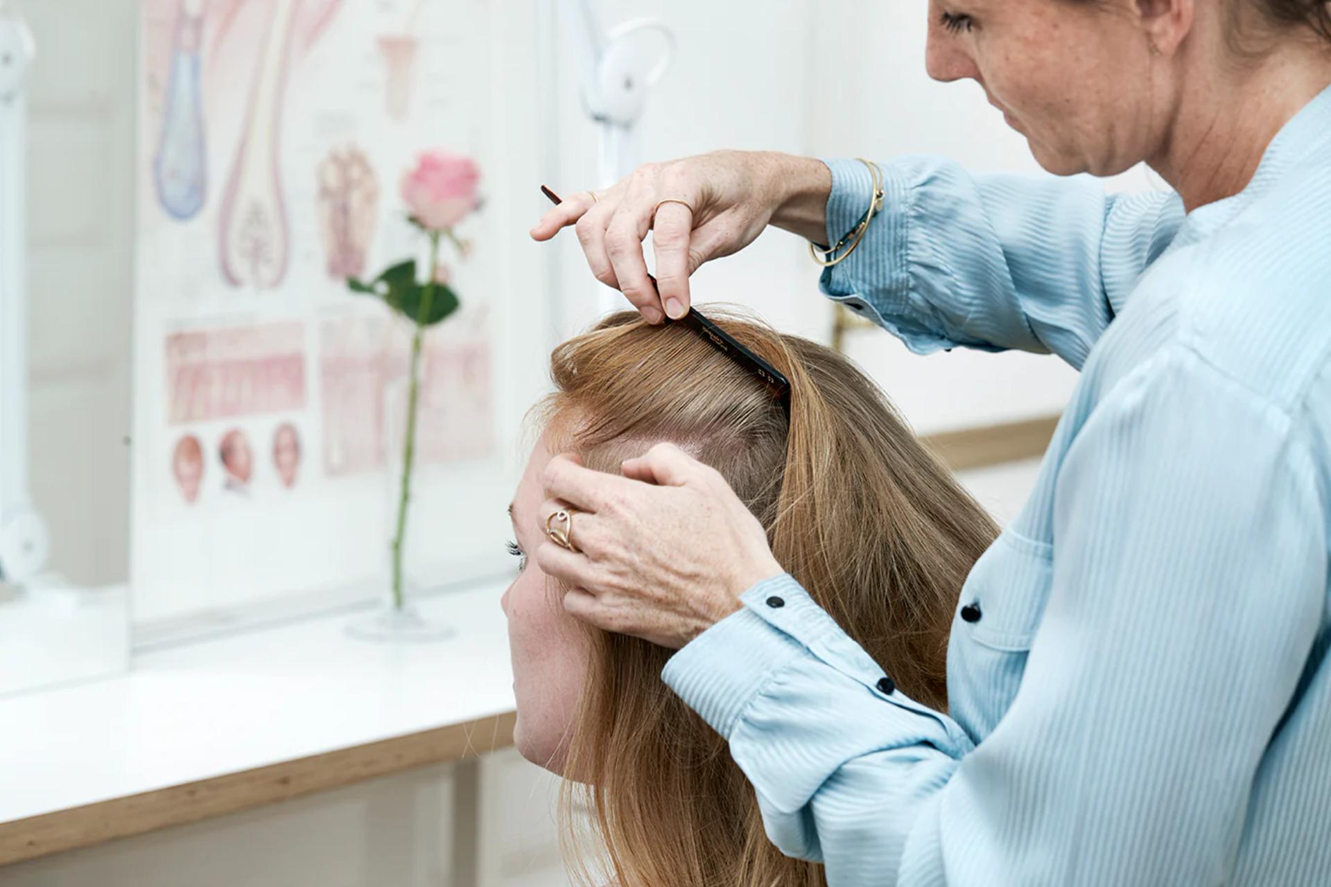 Side profile of a female having her hair parted and examined in a Harklinikken clinic