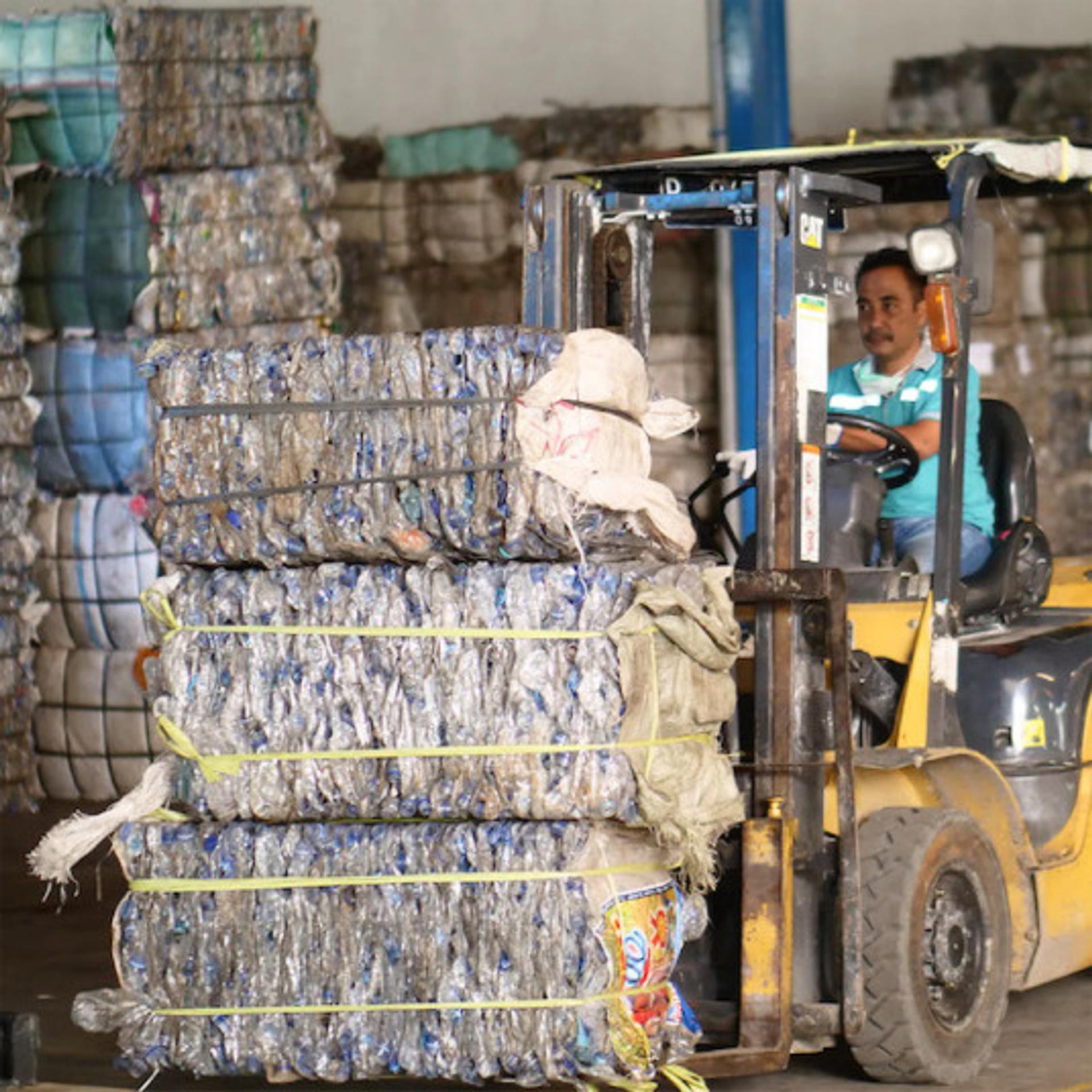 Man on Forklift moving recycled plastics in a factory