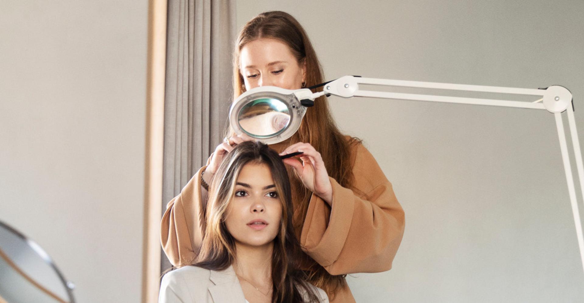 Harklinikken Consulation in Clinic with Scalp being checked over a magnifying glass