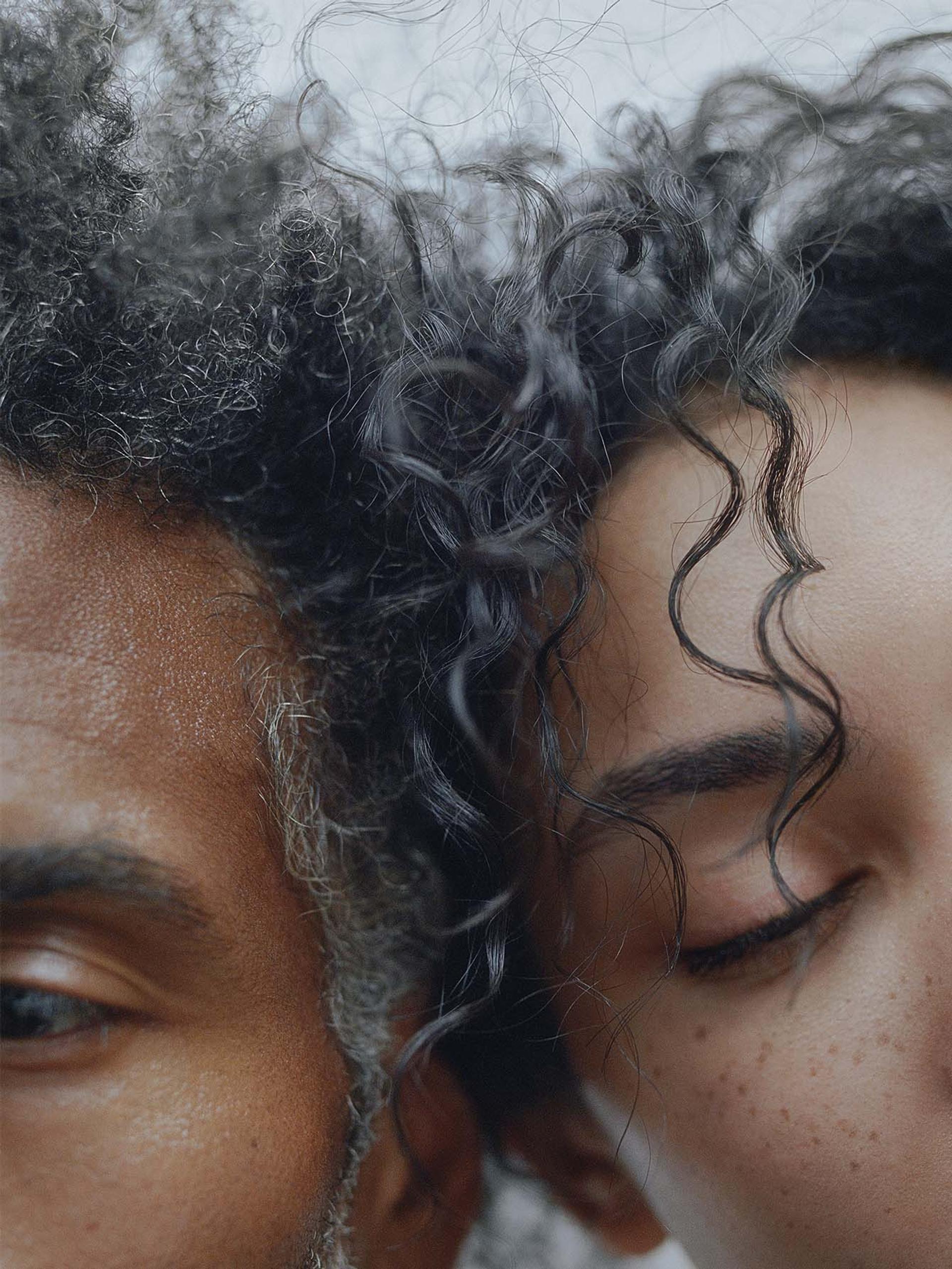 Photo of a female and male model side by side with dark curly afro hair