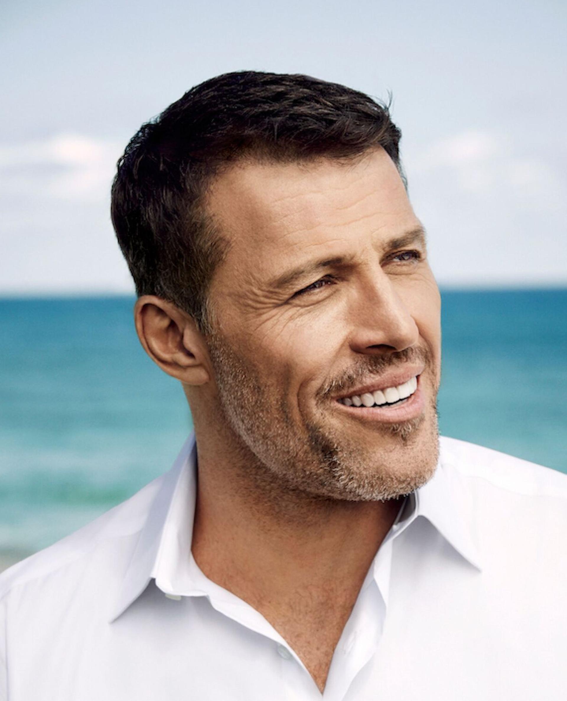 Tony Robbins Portrait Photo head turned smiling in front of sea