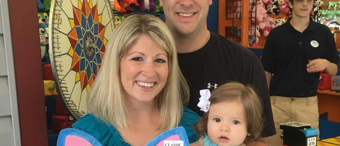 Mom, Dad, and baby in front of DelGrosso's Park Games.