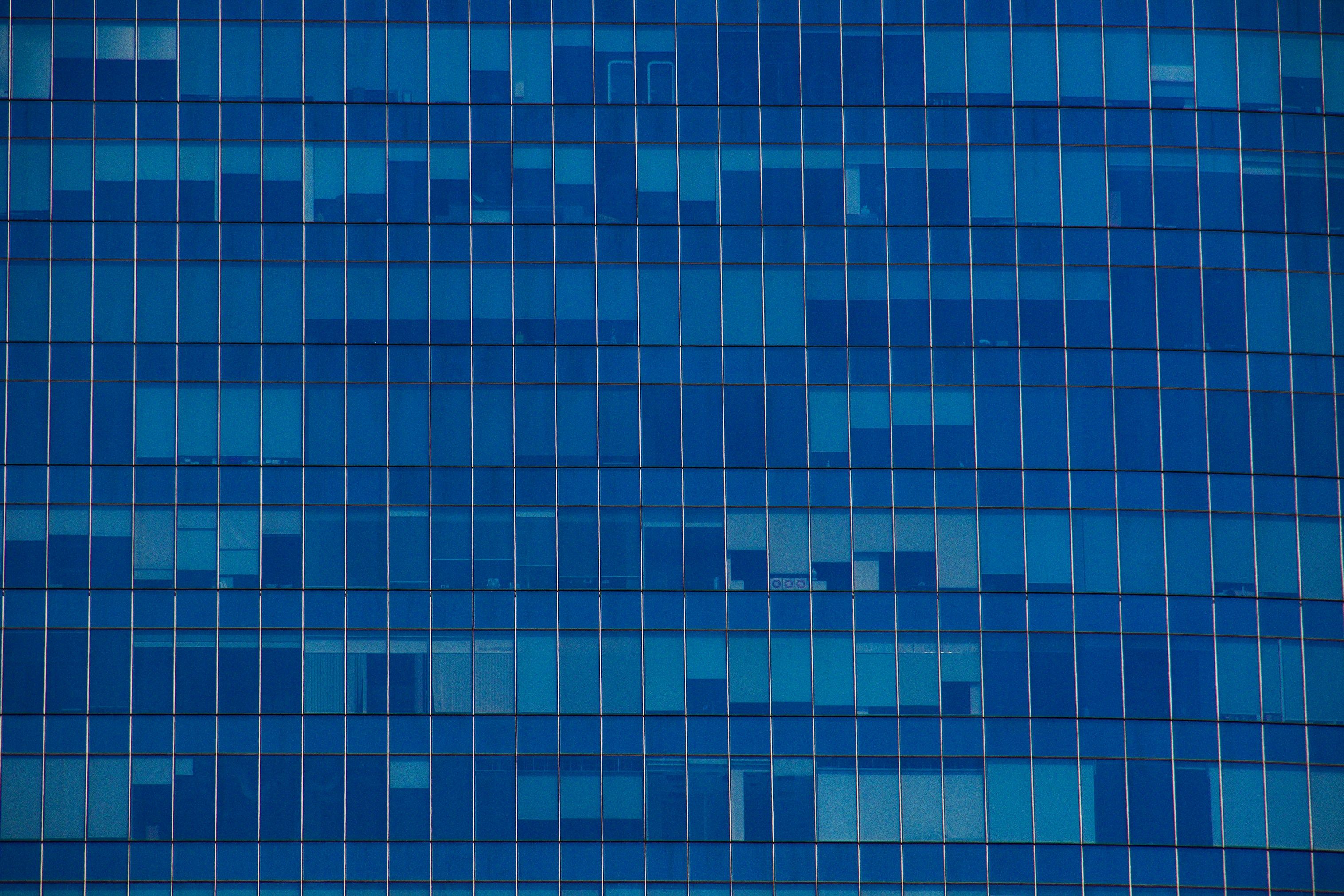 a close up of a blue glass building with a lot of windows .