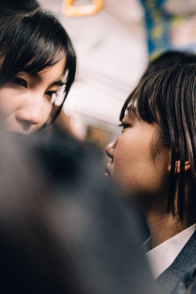Two young people in close profile in a quiet moment, shallow focus.