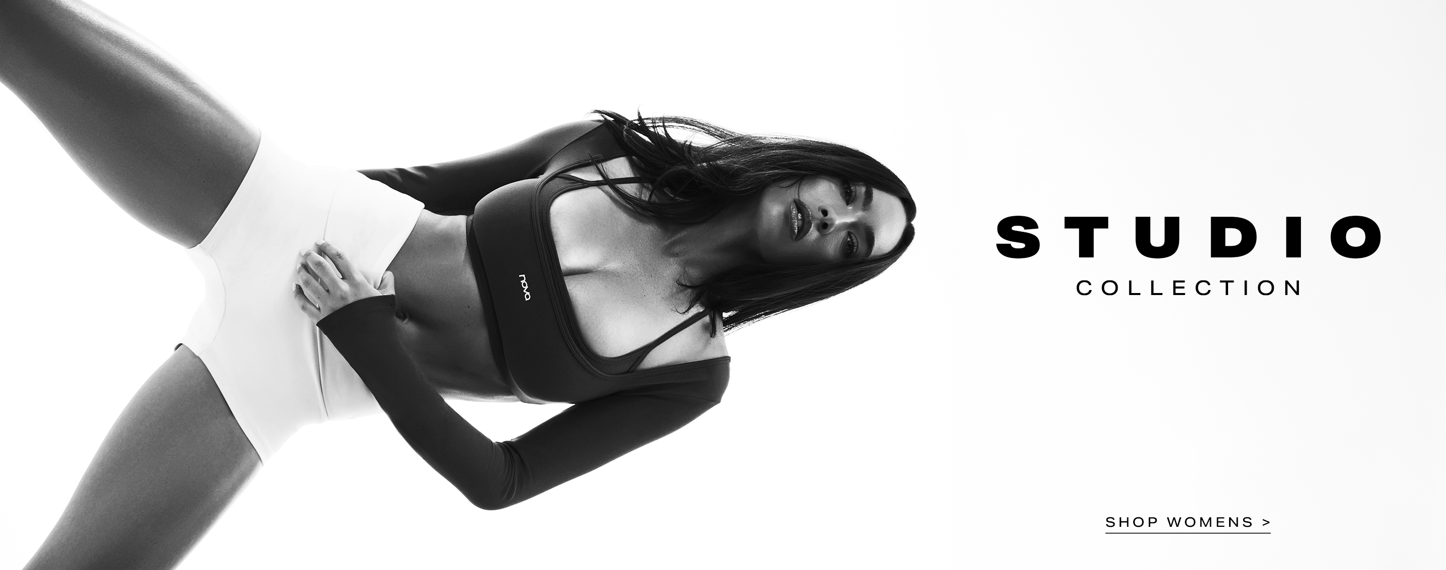 Dynamic woman in black Nova crop top and white shorts, promoting the new Studio Collection of women's activewear.
