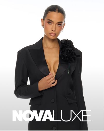 Woman wearing a chic black Nova Luxe designer blazer featuring large floral rose details, showcasing the new luxury evening wear collection.