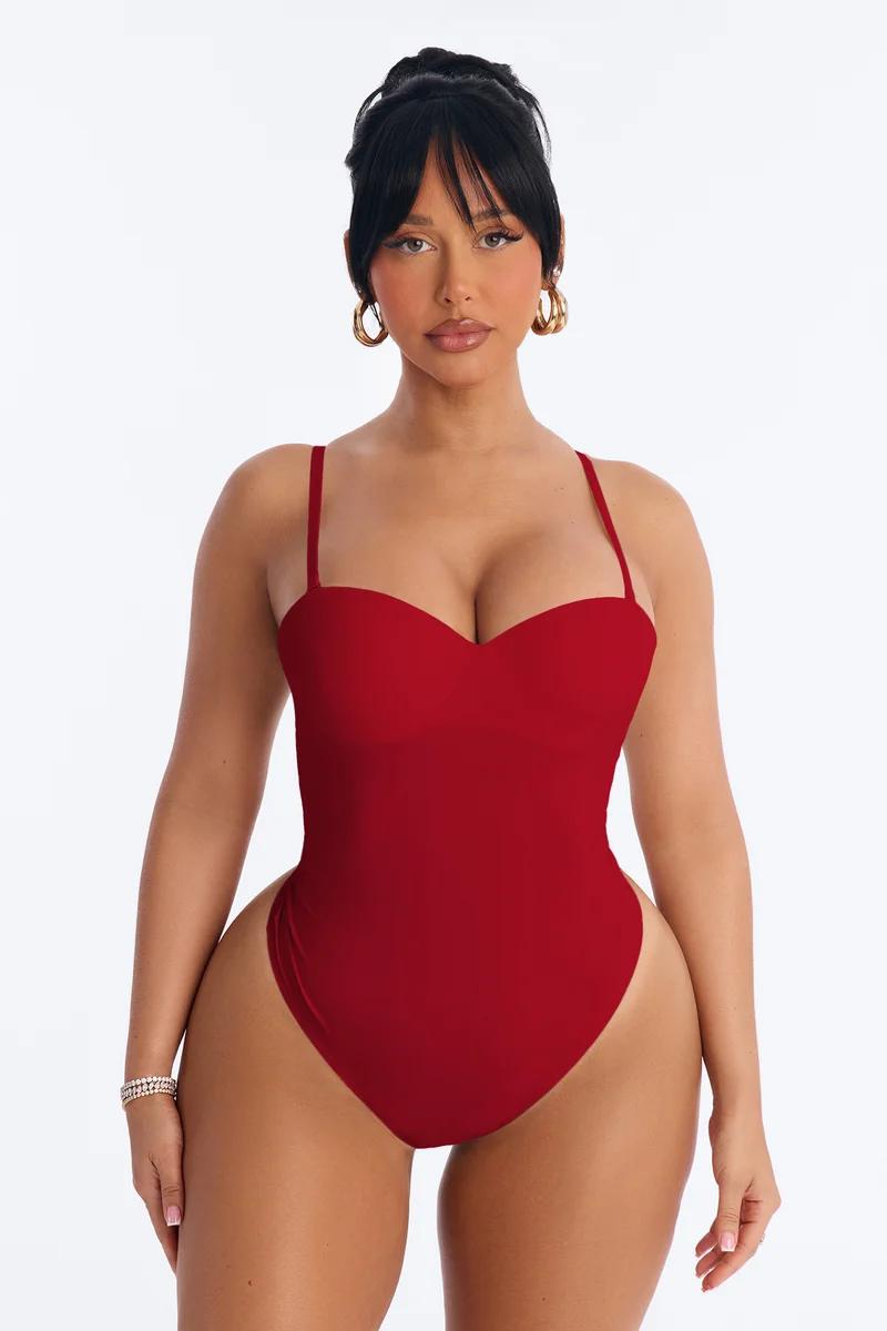 Woman wearing a fitted red shapewear bodysuit with a sweetheart neckline.
