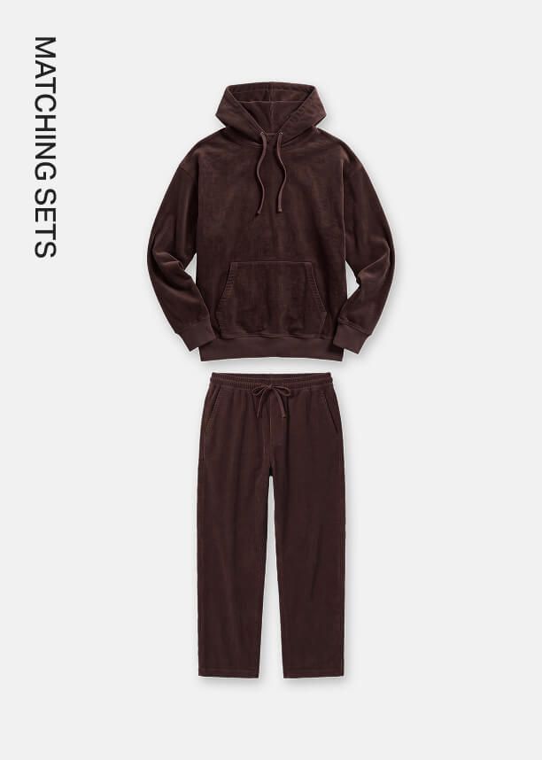 Dark brown velour hoodie and matching sweatpants set displayed against a neutral background, highlighting the matching sets collection.