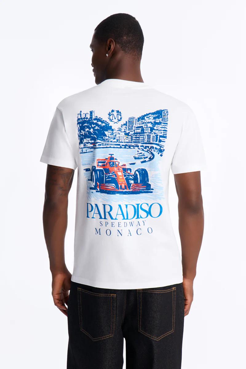 Camiseta gráfica blanca con horizonte azul de Mónaco, puerto y diseño de F1 naranja. Incluye 'Paradiso Speedway Monaco', nueva colección.
