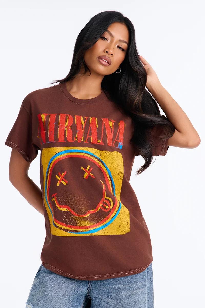 Model wearing a brown vintage graphic Nirvana t-shirt featuring the smiley face logo.