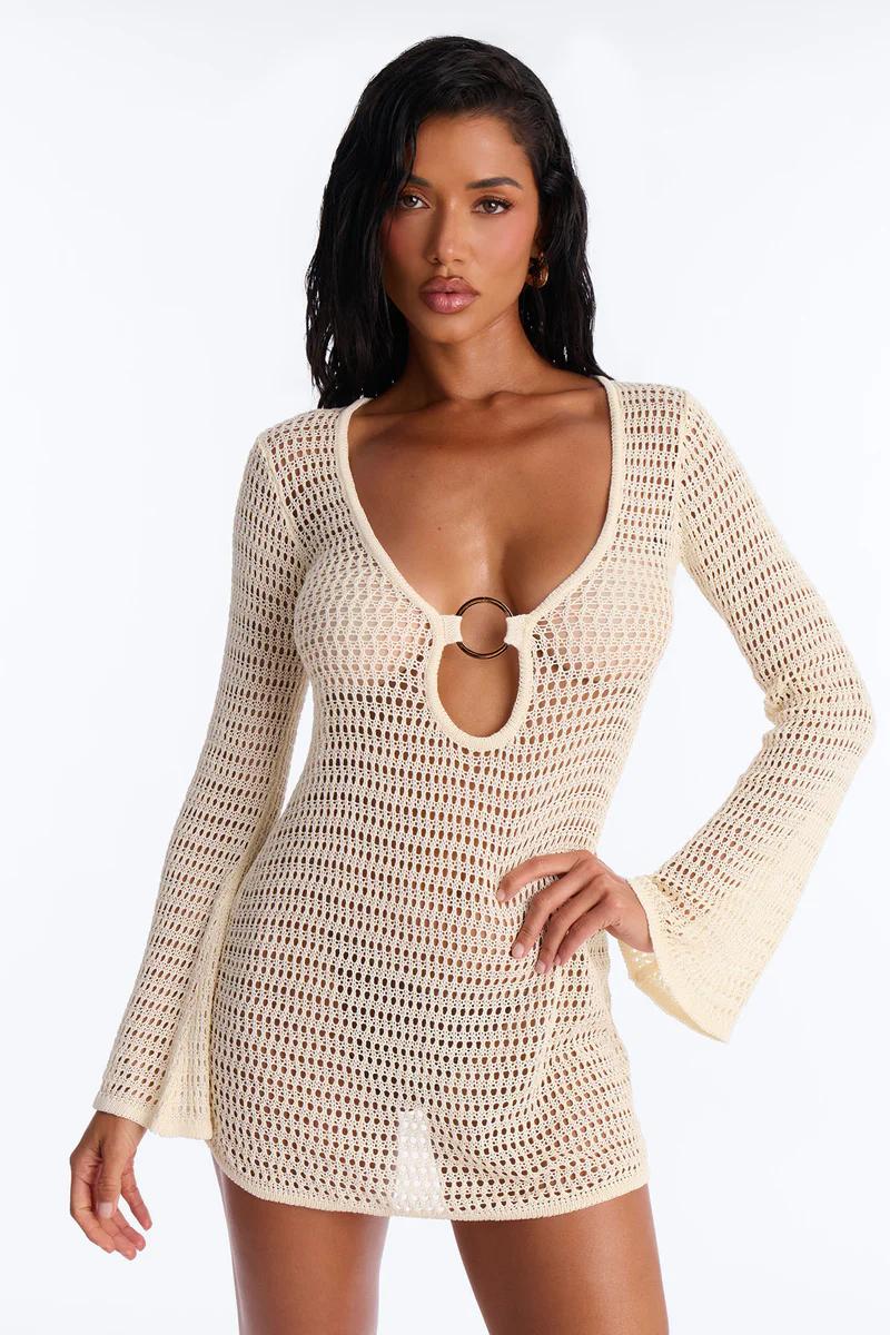 Cream long sleeve crochet mini dress featuring a keyhole and metal ring. Ideal sheer beach cover-up or resort wear.