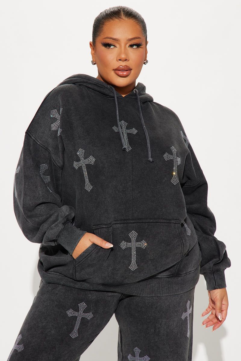 Plus size model in a dark gray acid wash hoodie with rhinestone cross designs and matching sweatpants.