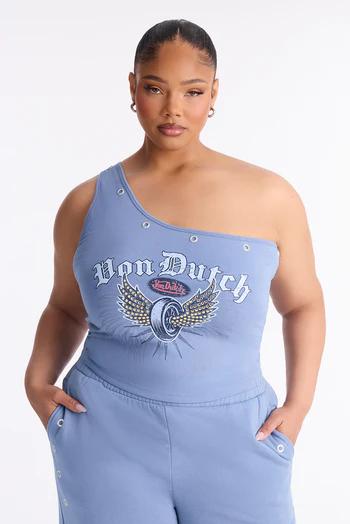 Woman looking at camera in a periwinkle blue one-shoulder top styled with silver grommets and a "Von Dutch" winged tire logo, matching bottoms.