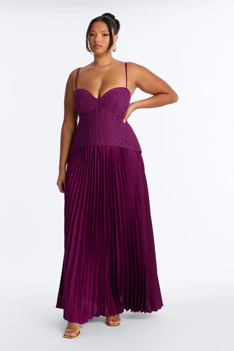Model wears a plus size purple formal dress featuring a lace corset bodice and a pleated maxi skirt, promoting the new evening wear collection.