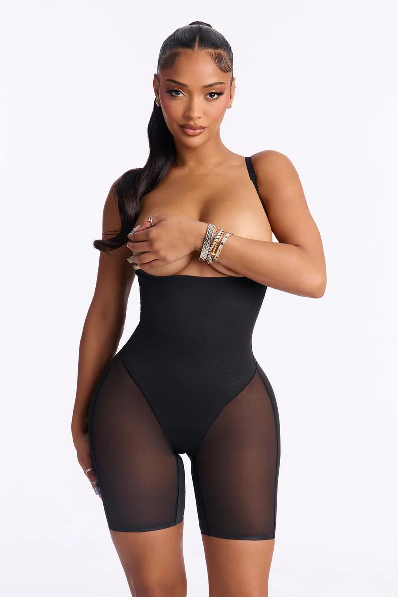 Woman in black sheer panel shapewear bodysuit. High-waist sculpting control shorts.