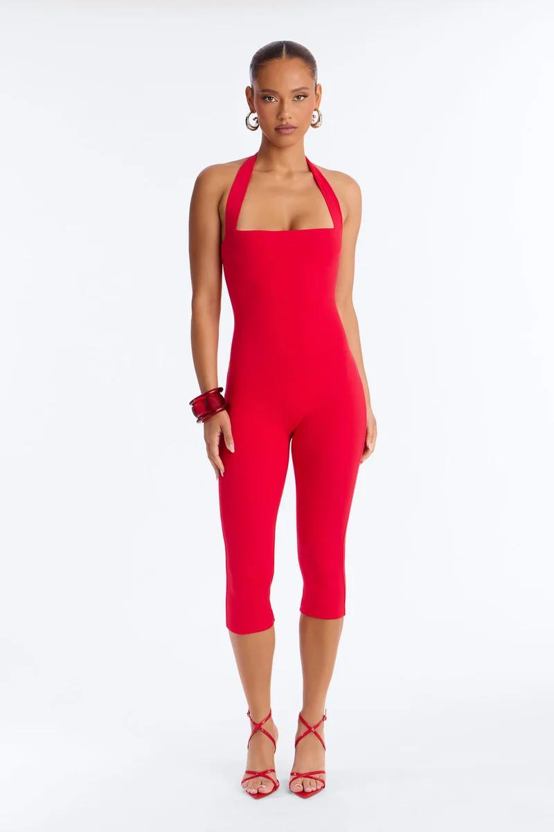 Stylish model in a brown one-shoulder cropped jumpsuit with gold accessories and sunglasses, showcasing chic new apparel.