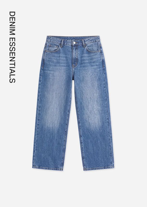 High-waisted straight leg blue jeans in a medium wash from the Denim Essentials collection, isolated on a light grey background.