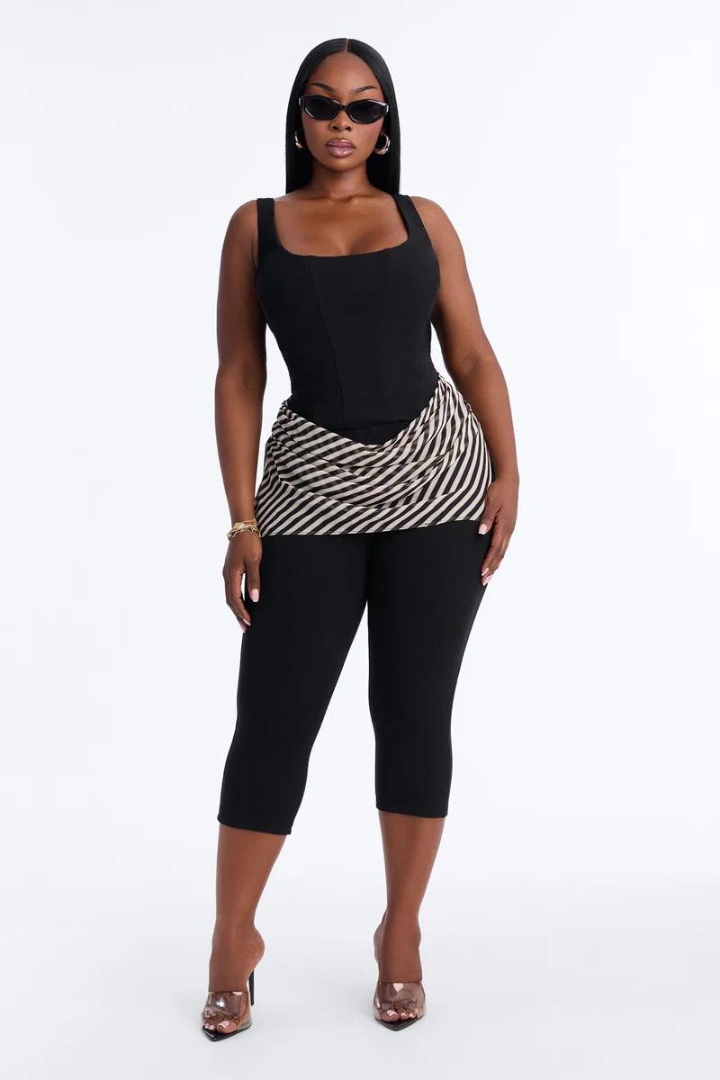 Vibrant pink and purple abstract print halter jumpsuit on a plus size model, complete with a matching headscarf. Discover our chic new collection.