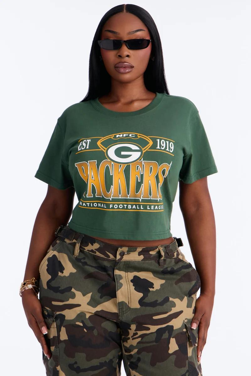 Woman in a green Green Bay Packers cropped graphic t-shirt and camo pants.