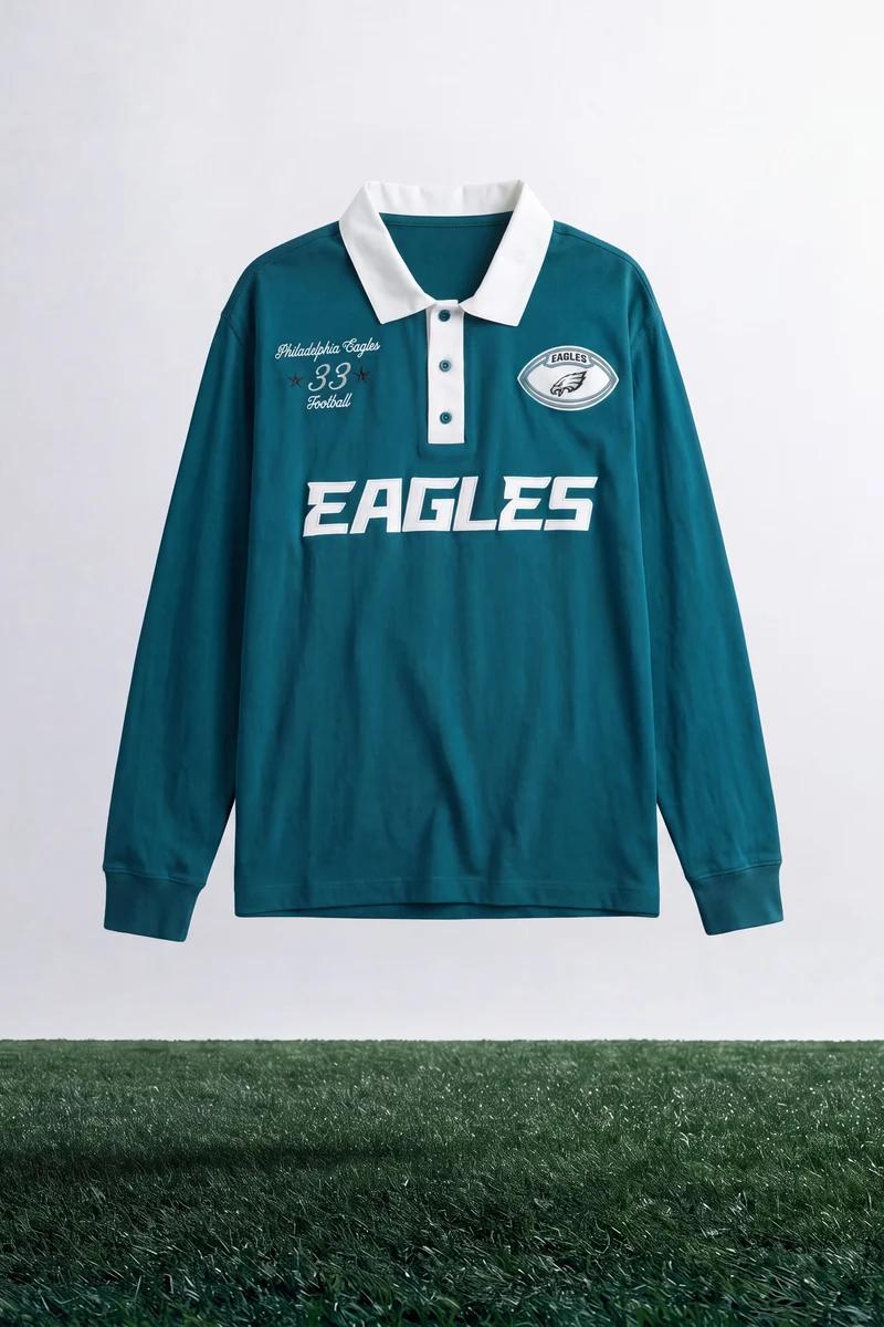 Teal long-sleeve Philadelphia Eagles rugby shirt features white collar, placket, and team graphics. Official football fan apparel.