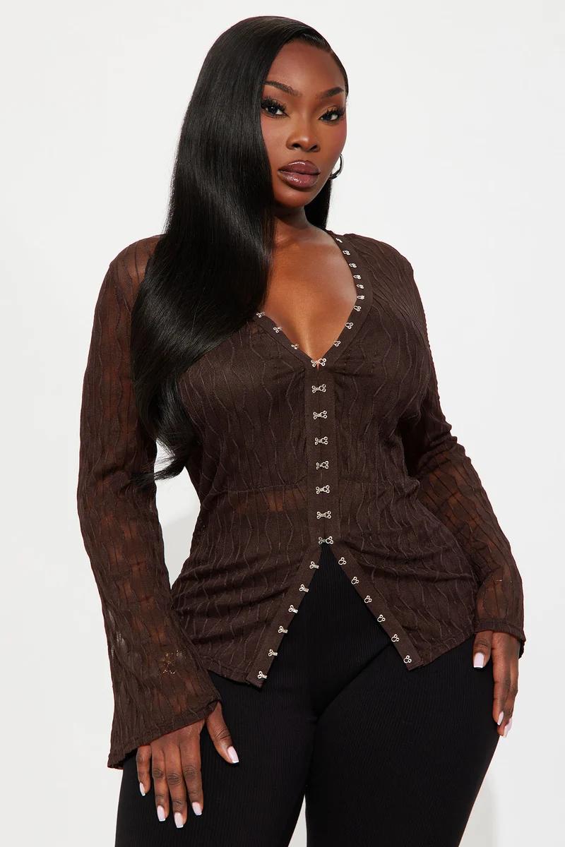Black woman wearing a brown sheer long sleeve top with front hook-and-eye closures.