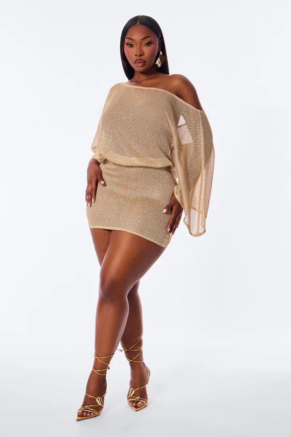 Mujer en minivestido dorado de punto con hombros descubiertos y mangas amplias, tacones dorados con cordones, ideal para fiesta.