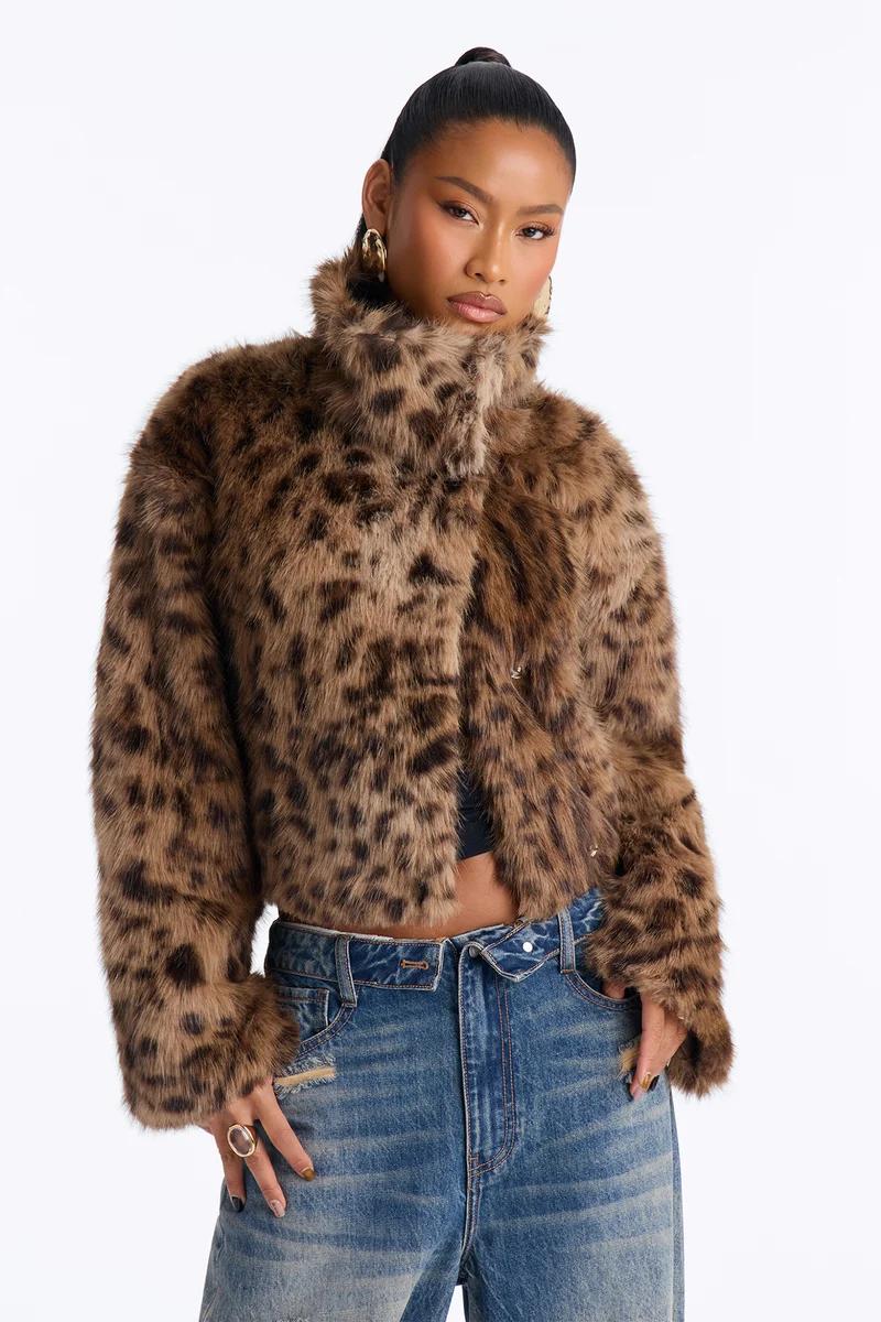 Model wearing a cropped leopard print faux fur coat and blue jeans.
