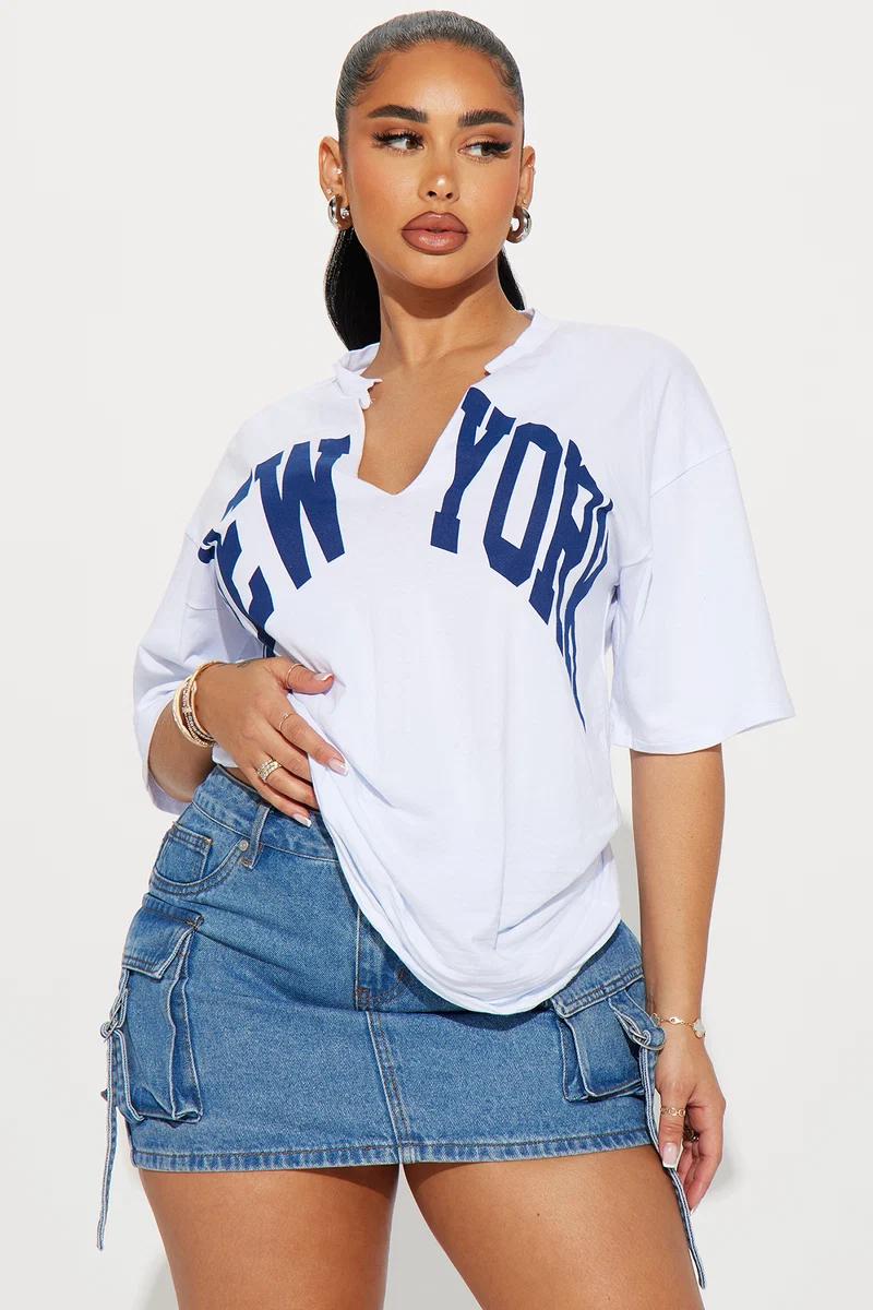 Mujer con camiseta blanca de Nueva York y minifalda vaquera tipo cargo.
