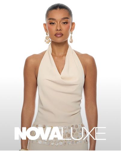 Woman models elegant cream cowl neck halter top with gleaming gold statement earrings, showcasing sophisticated new fashion collection.