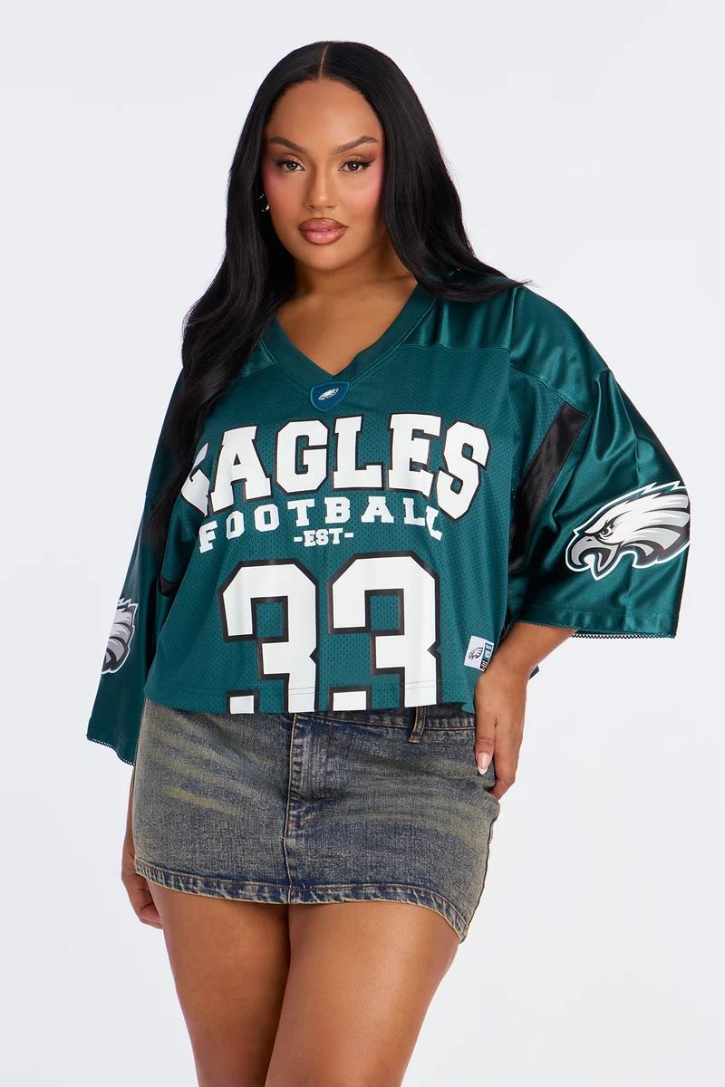Mujer de talla grande con jersey corto de los Philadelphia Eagles y minifalda de mezclilla.