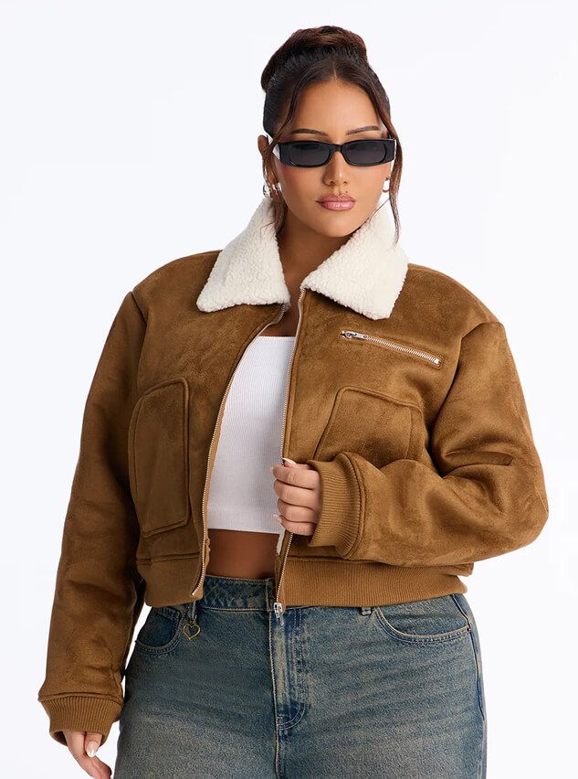 Cozy brown faux suede bomber jacket with a white sherpa collar, worn with jeans to showcase the new women's fall outerwear collection.