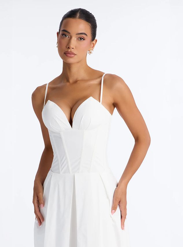 Model wears an elegant white corset dress with sweetheart neckline, showcasing a chic bridal style against a clean white background.