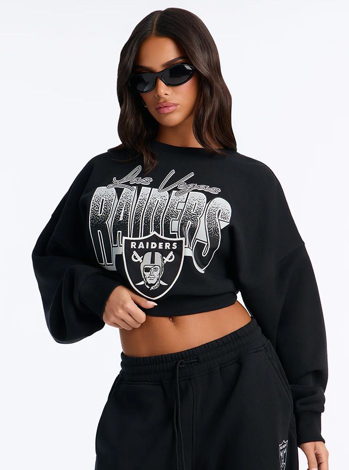 Mujer con sudadera corta negra de Las Vegas Raiders y pantalones deportivos.