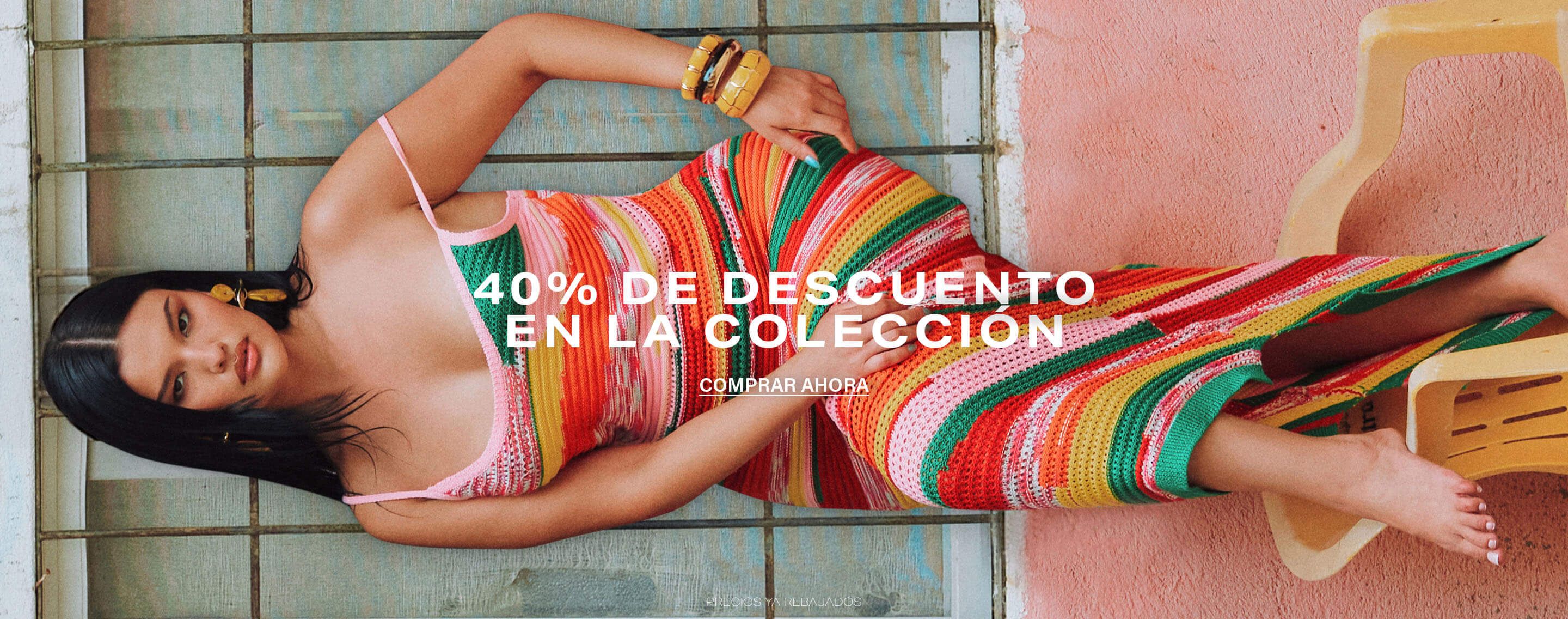 Mujer con vestido ganchillo rayas multicolor frente a pared rosa. Promociona 40% de descuento en colección de moda. ¡Compra ya!