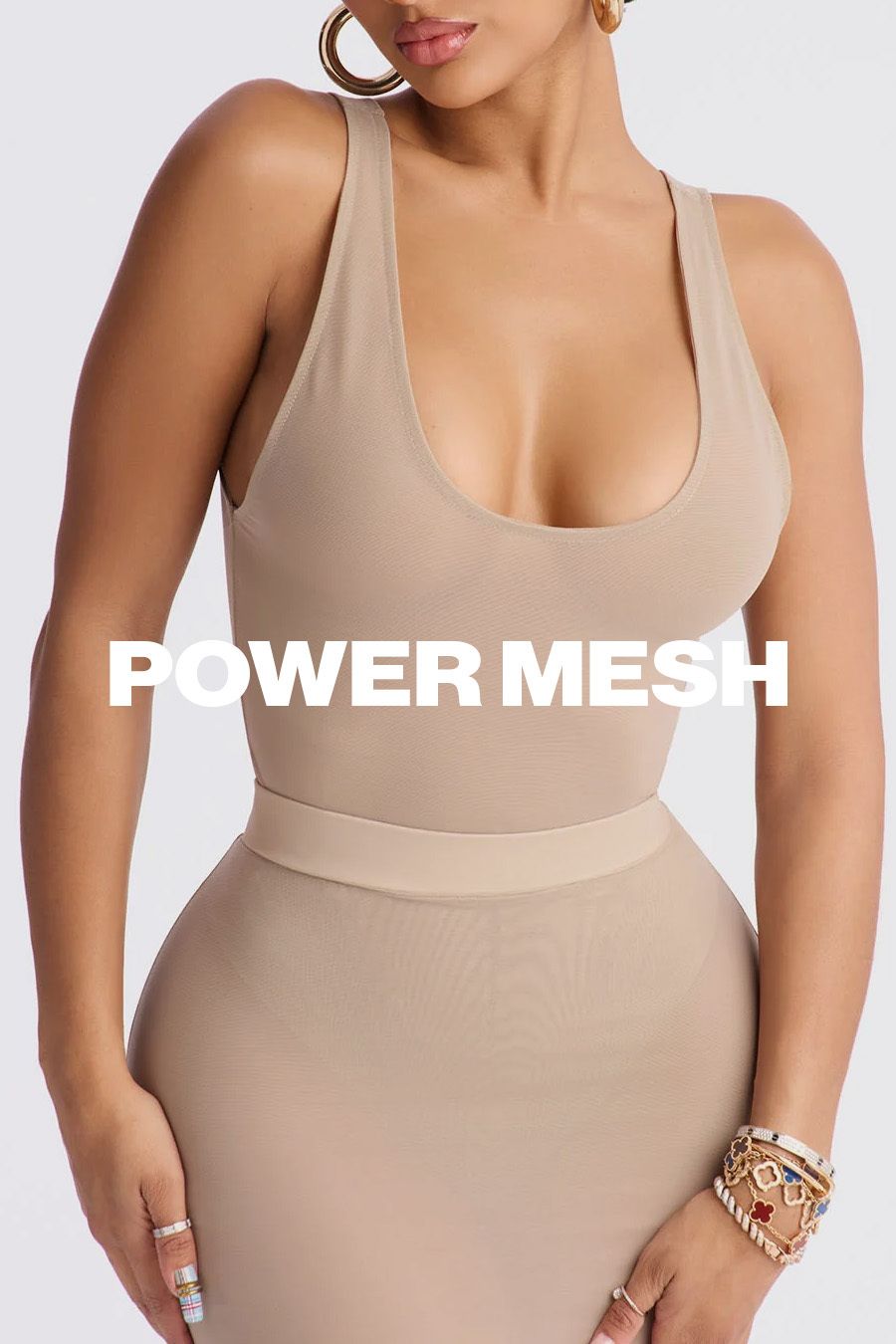 Mujer luce la nueva colección Power Mesh con un top y falda nude ajustados, resaltando la ropa moldeadora transpirable.