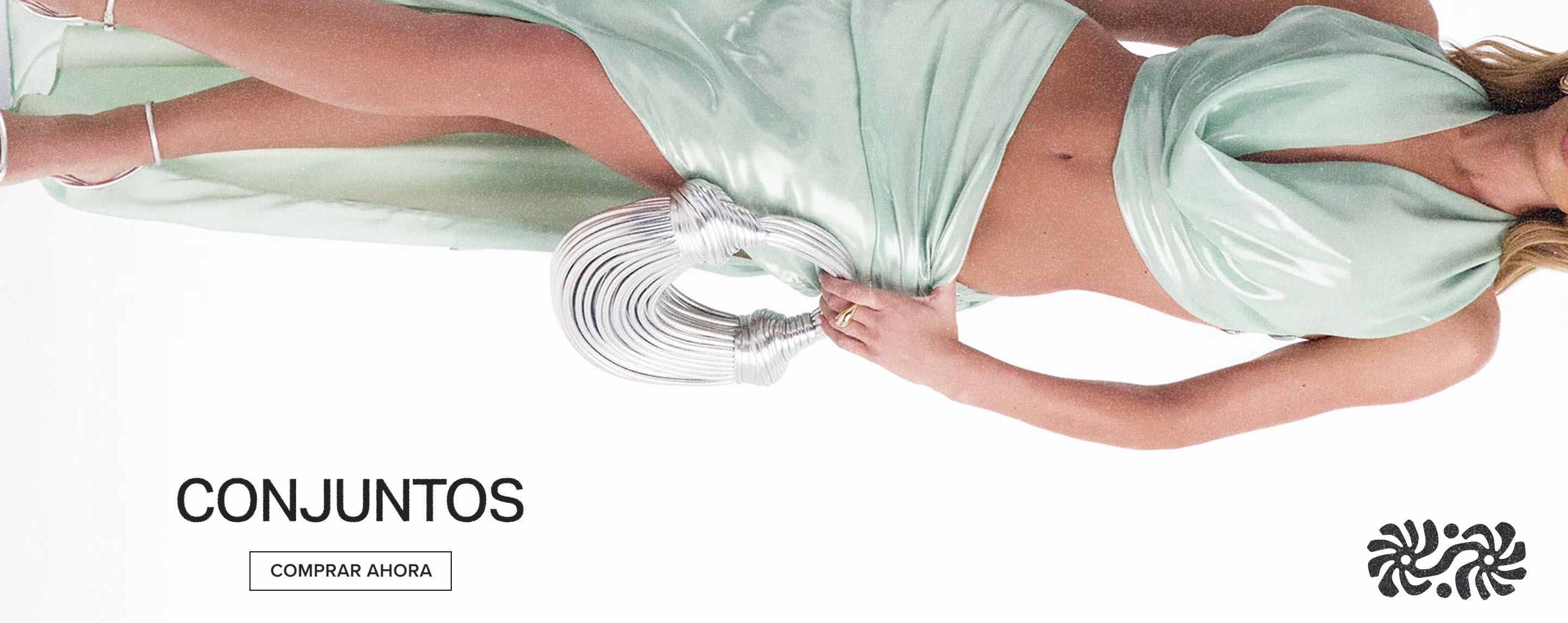 Modelo con un conjunto de moda brillante verde menta, sujetando un bolso plateado. Explora nuestros conjuntos y compra ahora.