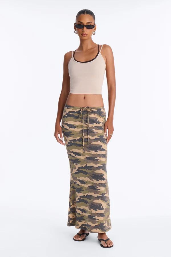 Woman in a beige cropped tank top and low-rise camouflage maxi skirt with drawstring, showcasing a trendy Y2K-inspired casual summer outfit.