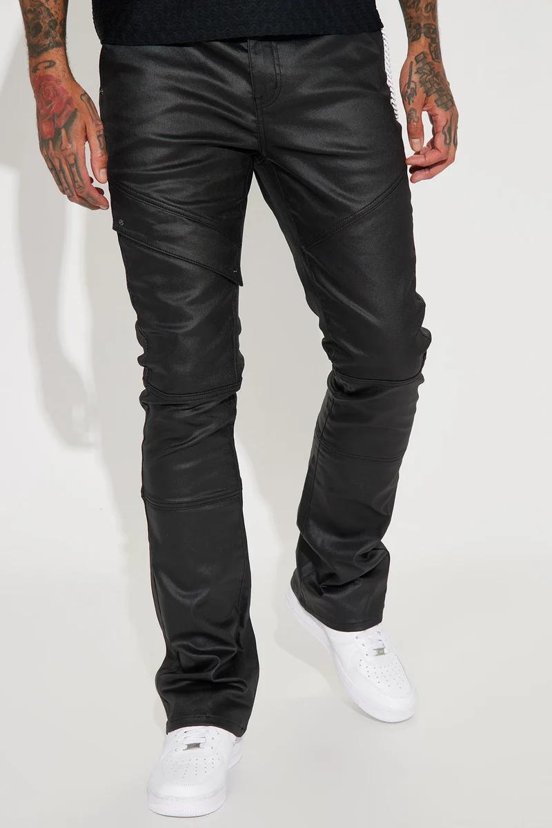 Man in black paneled waxed pants and white sneakers, showcasing edgy men's fashion. Explore our new collection of stylish pants.