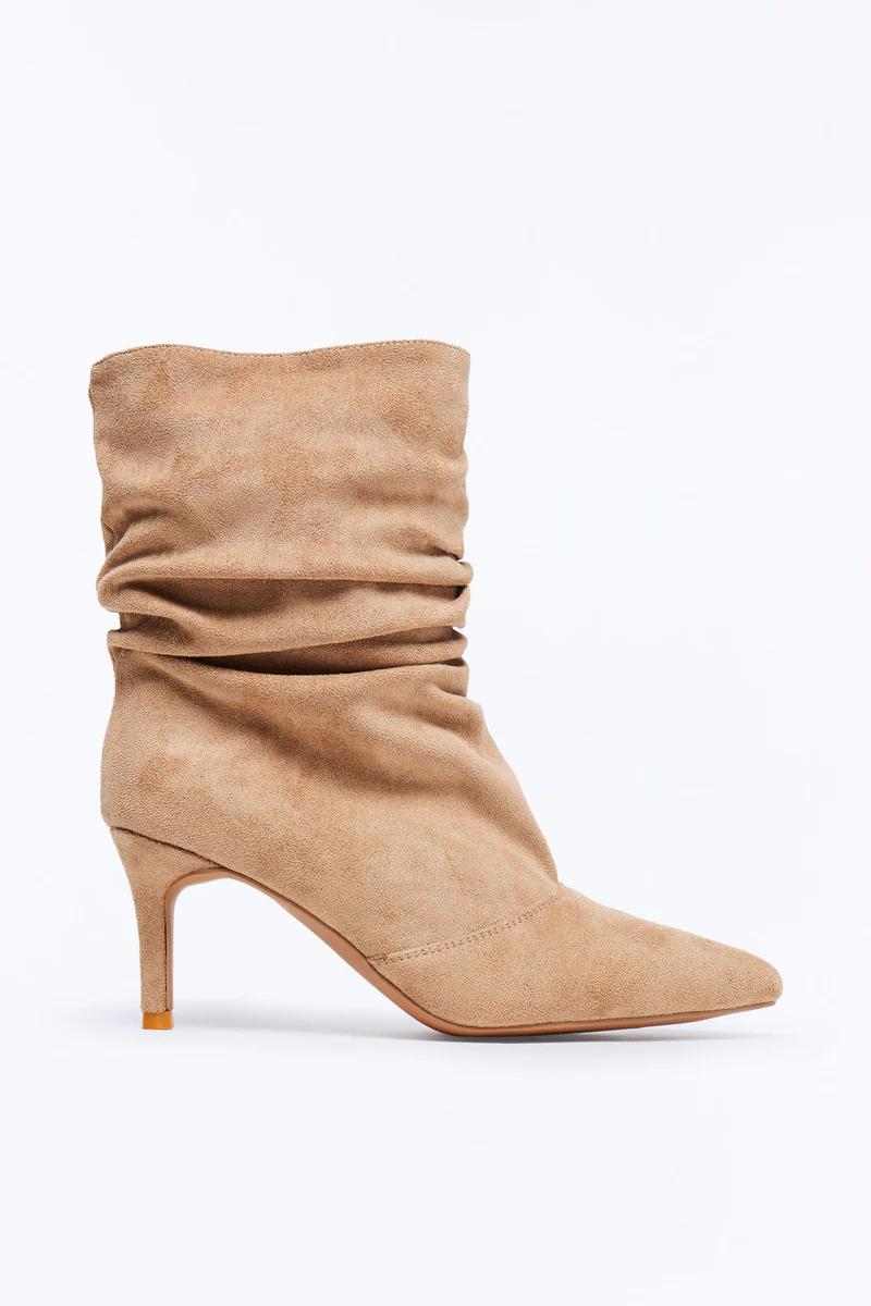 A single chic tan suede slouchy ankle boot with a pointed toe and a sleek kitten heel, positioned on a clean white surface.
