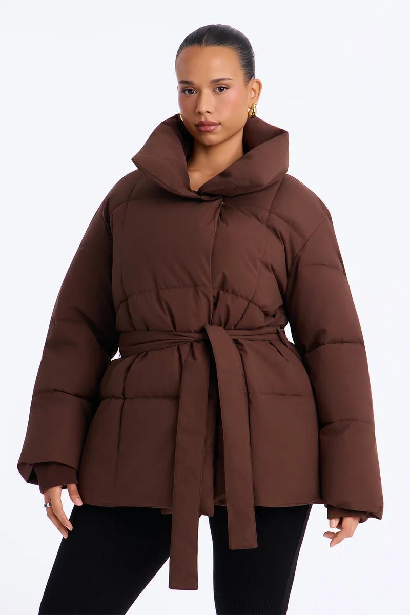 Chaqueta acolchada marrón chocolate para mujer con cinturón y cuello alto.
