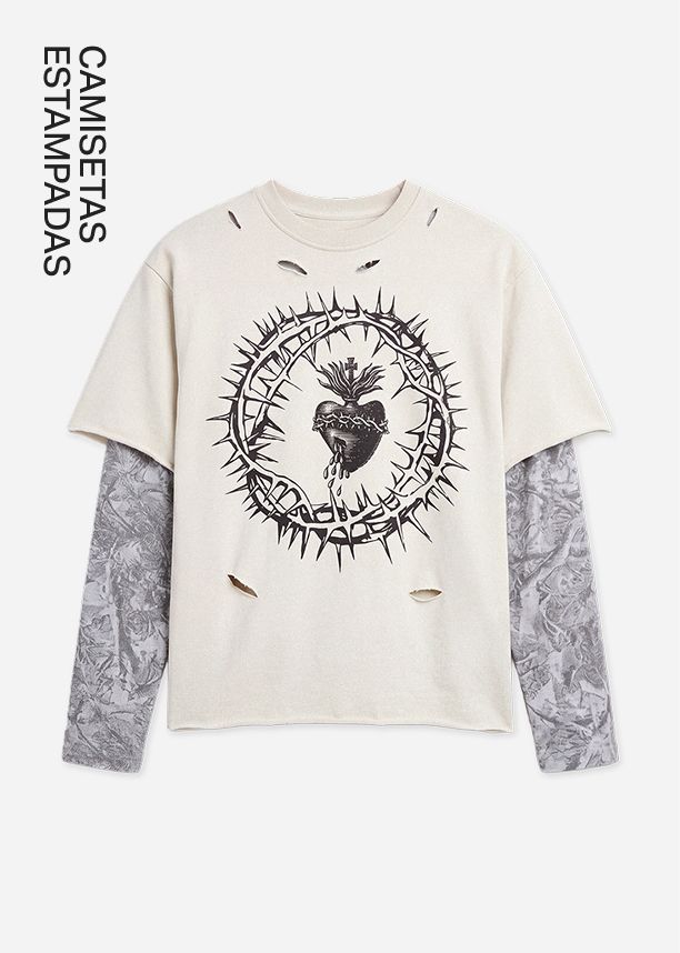 Camiseta beige desgastada con un sagrado corazón entre espinas, sobrepuesta con mangas largas grises estampadas de estilo grunge alternativo.