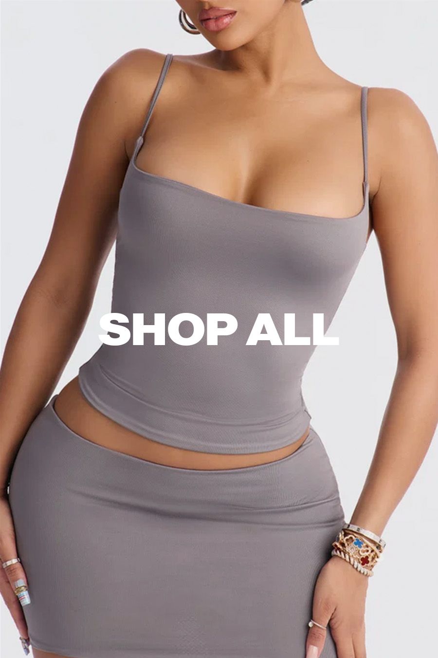 Mujer vistiendo un conjunto gris de dos piezas con texto "SHOP ALL" superpuesto para explorar la colección completa de moda femenina.